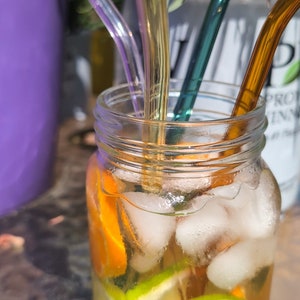 Cuatro pajitas de vidrio de colores con cepillo limpiador. caja de cartón. alta calidad sin sabor químico mientras bebes tu bebida favorita.