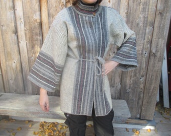 May include: A gray, long-sleeved coat with a high collar and a matching belt. The coat features vertical stripes in shades of gray, white, and red. The sleeves have a flared design with striped cuffs. The coat is buttoned down the front.