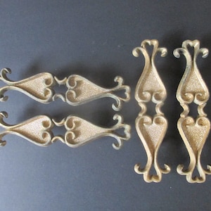 May include: Set of five gold-toned metal drawer pulls with ornate, heart-shaped designs.