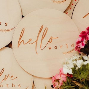 Hallo wereld | Zwangerschaps- en geboorteaankondiging | Zij/Hij is hier | Houten baby mijlpaalkaarten schijf | Geslachtsneutraal | Foto Prop