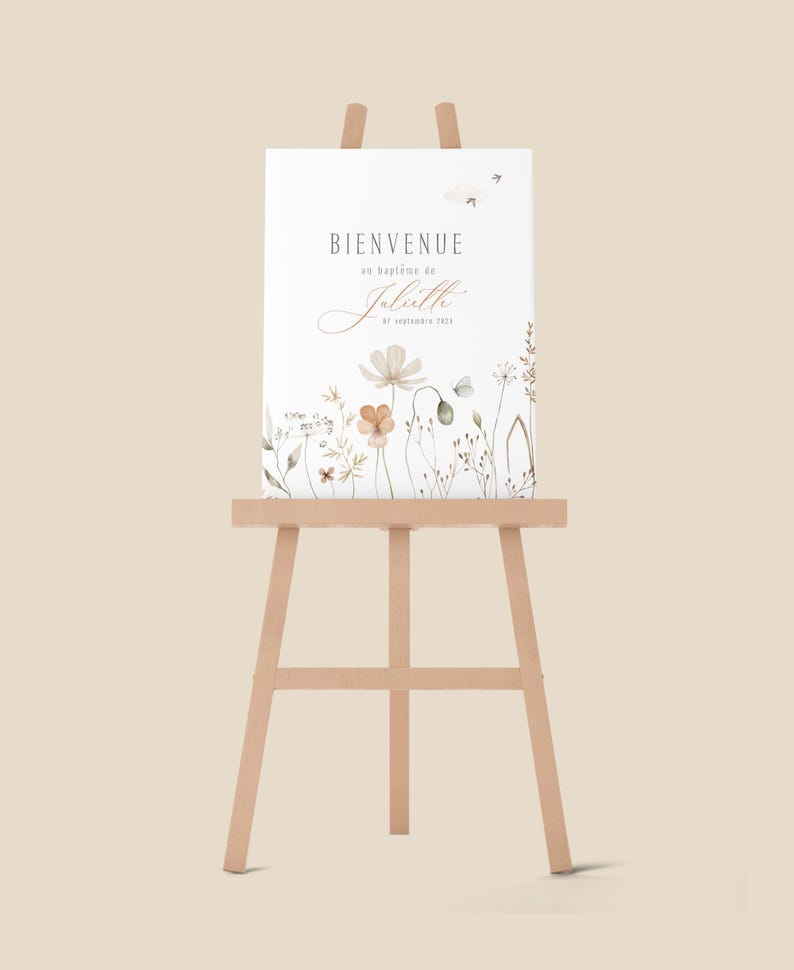 May include: A white sign with the text "Bienvenue au bapt&ecirc;me de Juliette 8 septembre 2023" and a watercolor illustration of flowers and butterflies. The sign is displayed on a wooden easel.