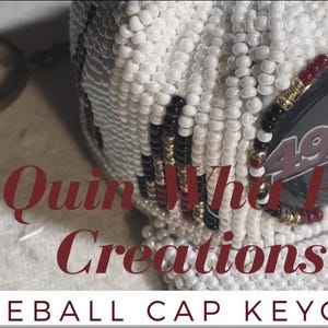Könnte beinhalten: Ein weißer, perlenbesetzter Baseballcap-Schlüsselanhänger mit einem schwarzen und goldenen 49ers-Logo. Der Schlüsselanhänger ist an einem silbernen Schlüsselring befestigt. Der Text "Quin Whe Pa Creations" ist unter der Kappe sichtbar.