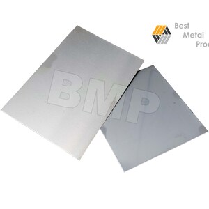 Puede incluir: Dos l&aacute;minas de metal pulido, una con acabado cepillado y la otra con acabado espejo. Las l&aacute;minas est&aacute;n etiquetadas con las letras "BMP" en blanco.