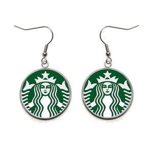 May include: A pair of silver dangle earrings with a green and white Starbucks logo on each earring.