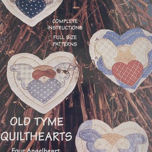 May include: A craft pattern package titled Old Tyme Quilthearts featuring four angel heart applique designs. The cover displays four heart-shaped fabric ornaments with various patterns and colors, including blue, white, and red, with text details.