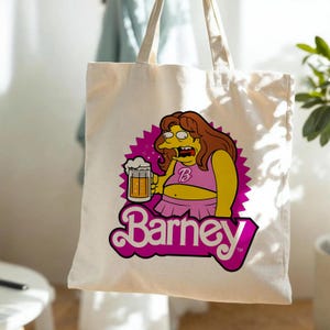 May include: A cream-colored canvas tote bag featuring a graphic print of a cartoon character with brown hair, wearing a pink top and skirt, holding a beer mug. The design includes a magenta starburst background and the text Barney in pink.