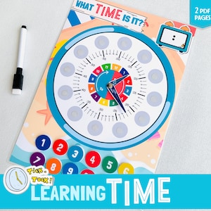 May include: A colorful learning clock with a blue face and a white background. The clock has numbers 1-12 and a colorful ring around the outside. The clock is surrounded by a beach scene with a starfish and waves. The text "WHAT TIME IS IT?" is at the top of the clock. The text "LEARNING TIME" is at the bottom of the clock. The text "Tick Tock!" is in a speech bubble next to the clock.