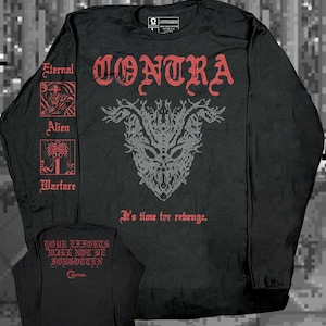May include: A black long-sleeve shirt featuring the red text CONTRA and a grey creature graphic on the front. The sleeve displays the red text Eternal, Alien, and Warfare with small illustrations. The back features the red text YOUR EFFORTS WILL NOT BE FORGOTTEN.