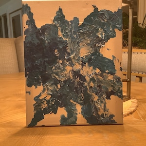 Può includere: Dipinto astratto su tela con vernice blu e bianca in un motivo a spirale.