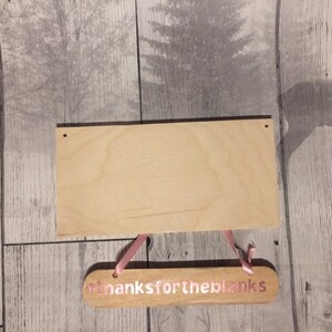 May include: Two wooden signs with pink lettering. The top sign is blank and the bottom sign says "thanks for the blanks".