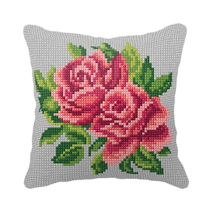 May include: A gray pillow with a cross-stitch design of two pink roses and green leaves.