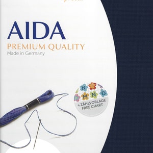 May include: A navy blue Zweigart Aida fabric precut measuring 19 inches by 21 inches. The packaging features the text AIDA PREMIUM QUALITY, a purple embroidery floss skein with a needle, and a circular sticker with a floral chart design.