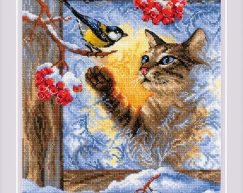 Op de afbeelding: Een bruine en witte kat met blauwe ogen kijkt uit een raam naar een gele en blauwe vogel die op een tak zit. Het raam is bedekt met rijp en er zijn rode bessen aan de takken buiten.
