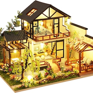 May include: A miniature dollhouse with a two-story design, featuring a brown wooden exterior, a white roof, and a detailed interior with furniture and lighting. The dollhouse is surrounded by a lush green garden with trees and flowers.