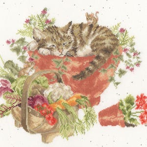 May include: Cross-stitch design featuring a tabby cat sleeping in a terracotta pot filled with greenery and flowers. A small mouse sits on the cat's back. A basket of vegetables and a broken pot with red flowers are also present.