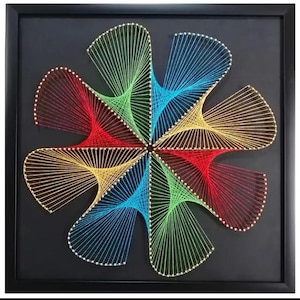 May include: A square black framed wall art piece featuring a geometric string art design. The artwork consists of colourful threads stretched between small nails on a black background, forming a six-petaled flower shape in red, yellow, blue, and green.