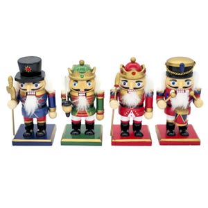 May include: A set of four wooden nutcracker figurines standing on square bases. Each figure wears a distinct uniform, including a black hat, a green crown, a red crown, and a gold hat. They feature white faux fur beards and painted details.