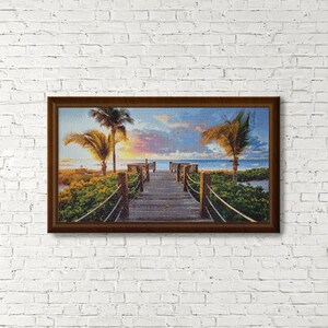 May include: A wooden walkway leads to the ocean with palm trees on either side. The sky is a vibrant mix of pink, orange, and blue, creating a beautiful sunset scene.