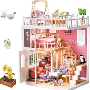 May include: A multi-level dollhouse featuring a pink bedroom with a bed, a living area with an orange sofa, a kitchen with a dining table, and a rooftop terrace with a swing. The walls include text reading Princess please rest and various decor.