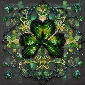 May include: A close-up of a beaded shamrock design with green, black, and white beads. The shamrock is surrounded by a decorative border of green and black beads.
