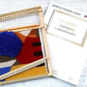 Puede incluir: Un telar de marco de madera con un tapiz tejido de colores en progreso. El telar est&aacute; hecho de madera natural y tiene un dise&ntilde;o simple. El tapiz presenta formas geom&eacute;tricas en tonos de rojo, azul, amarillo y marr&oacute;n. El telar est&aacute; etiquetado como "SIMPLE FRAME LOOM" y "LUCA-S".