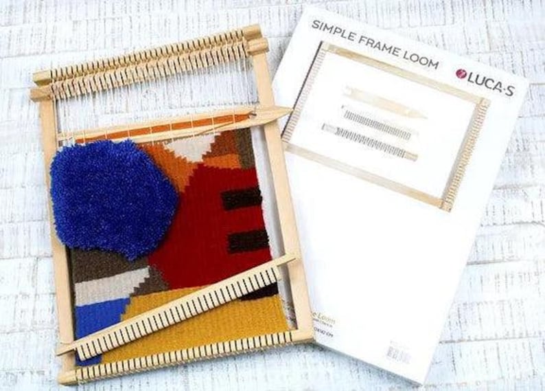 Puede incluir: Un telar de marco de madera con un tapiz tejido de colores en progreso. El telar est&aacute; hecho de madera natural y tiene un dise&ntilde;o simple. El tapiz presenta formas geom&eacute;tricas en tonos de rojo, azul, amarillo y marr&oacute;n. El telar est&aacute; etiquetado como "SIMPLE FRAME LOOM" y "LUCA-S".