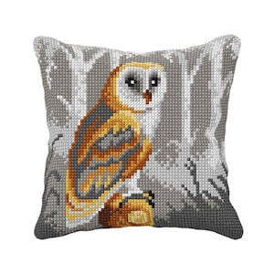 May include: A gray and white pillow with a cross-stitch design of a brown and white owl in a forest setting.