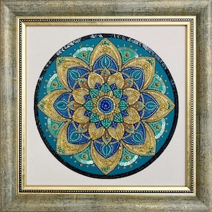 May include: A circular mandala wall art piece featuring intricate beadwork and sequins in shades of teal, royal blue, and metallic gold. The design is composed of layered petal shapes radiating from a central point, all encased in a square frame.