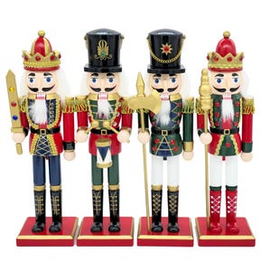Peut inclure: Un ensemble de quatre casse-noisettes en bois sur des socles carrés rouges. Chaque figurine porte un uniforme avec des bordures dorées, un haut chapeau et une barbe blanche. Ils tiennent des accessoires comme une épée, un tambour, une hache et un bâton.