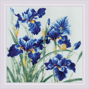 May include: Cross-stitch artwork featuring vibrant blue iris flowers with yellow accents and green foliage. A small snail is visible on one of the leaves. The artwork is framed in a white border, creating a classic and detailed floral design.