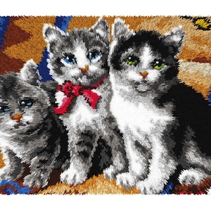 May include: A colorful image of three kittens with blue and green eyes. One kitten wears a red bow. The kittens are gray, black, and white, and are sitting on a patterned rug with blue, brown, and yellow hues. The image has a textured, almost 3D appearance.