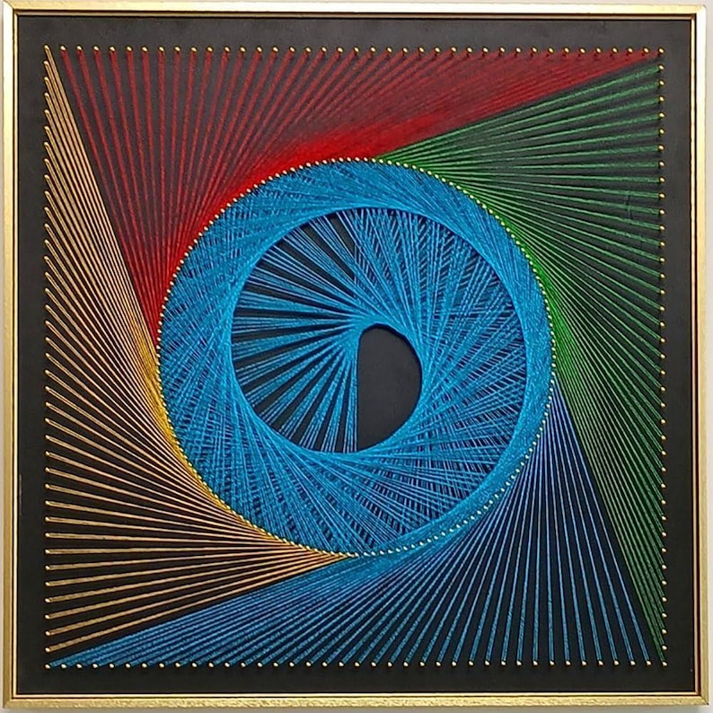 May include: A square string art piece featuring a central blue spiral pattern surrounded by geometric lines in red, green, gold, and blue. The design is created with thin threads wrapped around small gold nails on a black board in a gold frame.