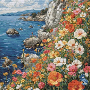 May include: A colorful cross-stitch landscape depicts a coastal scene. The image features a rocky cliff covered in vibrant wildflowers in shades of orange, yellow, pink, and white. The ocean is a deep blue, and the sky is a light blue with fluffy white clouds.