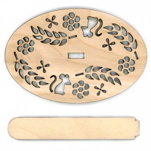 May include: A wooden oval-shaped ornament with a cutout design of flowers, leaves, and a mouse. The ornament is unfinished and ready to be painted or stained. It comes with a separate wooden dowel.
