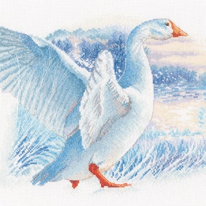 May include: A white goose with orange legs and a long neck is flying with its wings spread wide. The goose is in front of a blue and white background that looks like a snowy landscape.
