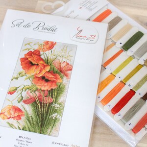 May include: A cross-stitch kit featuring a vibrant floral design of orange poppies and green foliage. The kit includes a printed pattern, embroidery floss in various colors, and the text "Set de Brodat".