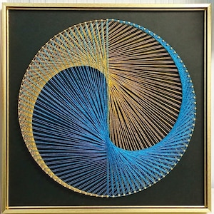 May include: A square wall art piece featuring a circular string art design on a black background. The design uses metallic gold and bright blue threads wrapped around small pins to create a swirling, geometric pattern inside a gold frame.