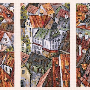 May include: A triptych of paintings depicting a stylized cityscape with colorful buildings and rooftops. The buildings are painted in shades of red, orange, yellow, green, and blue. The paintings are framed in white.