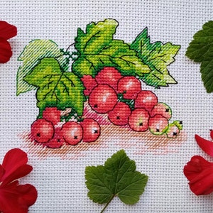 May include: Cross-stitch embroidery of a bunch of red currants with green leaves on a white background.