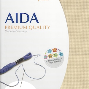 May include: Zweigart Aida premium quality fabric in beige, measuring 19 inches by 21 inches or 48 cm by 53 cm. The packaging includes a skein of purple embroidery floss, a needle, and a free chart featuring colorful flower illustrations.