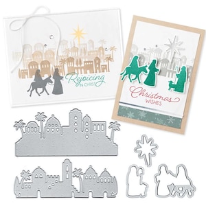 May include: Two handmade greeting cards featuring a nativity scene with a town silhouette, a star, and the text "Rejoicing in Christ" and "Christmas WISHES," accompanied by silver metal cutting dies of the town, star, and nativity figures.