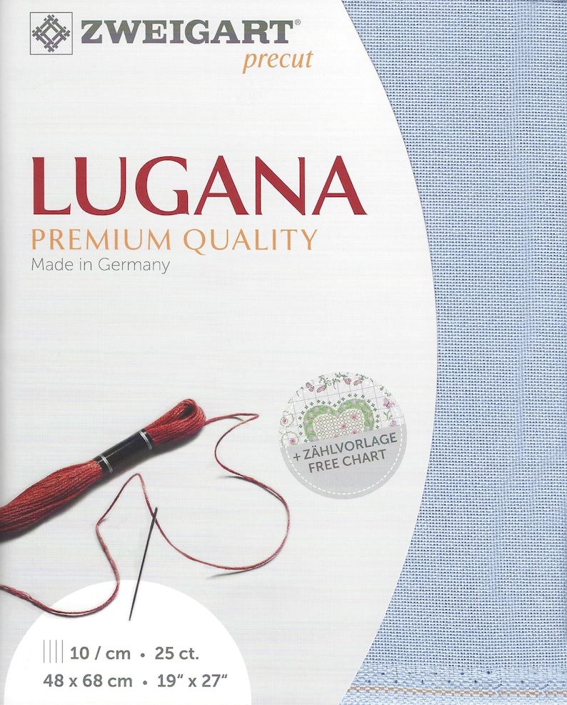 Peut inclure: Un tissu en toile Aida bleu clair pour point de croix, avec le texte "ZWEIGART precut LUGANA PREMIUM QUALITY Made in Germany" et "10/cm - 25 ct. 48 x 68 cm - 19" x 27" ". Un fil &agrave; broder rouge est enroul&eacute; autour d'une aiguille et un cercle avec le texte "+ Z&Auml;HLVORLAGE FREE CHART" se trouve dans le coin sup&eacute;rieur droit.