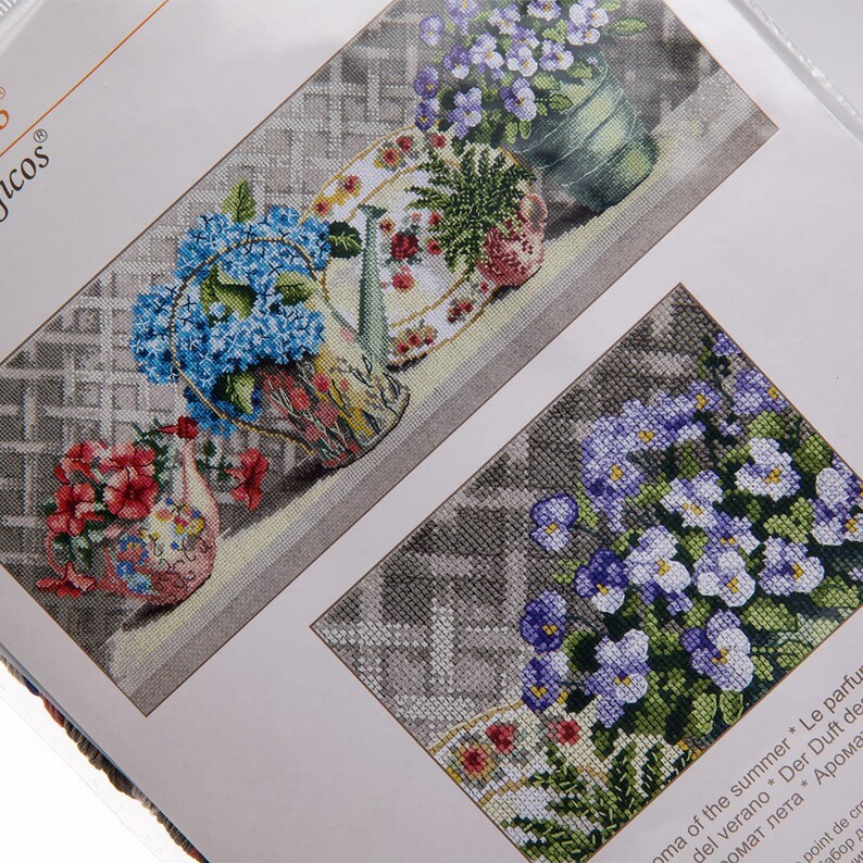 Pu&ograve; includere: Schemi a punto croce con disegni di nature morte floreali. I modelli raffigurano vasi e piatti pieni di fiori colorati, tra cui ortensie blu e fiori rossi, su uno sfondo grigio. I disegni sono dettagliati e intricati, mostrando una variet&agrave; di colori.