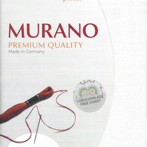 May include: White Aida cloth with a red thread and needle, a small circle with the text "Z&Auml;HLVORLAGE FREE CHART" and the text "MURANO PREMIUM QUALITY Made in Germany 12.6/cm. 32 ct. 48 x 68 cm 19" x 27"