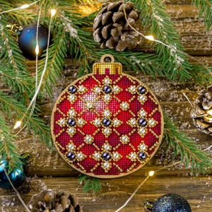 May include: A red and gold Christmas ornament with a beaded design. The ornament is made of felt and has a loop for hanging.
