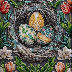 May include: A beaded artwork depicting a bird's nest with three intricately designed eggs. The nest is surrounded by green leaves and white flowers.