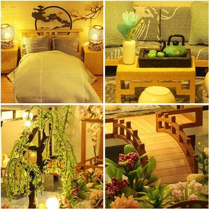 May include: A miniature dollhouse with a bedroom, living room, and garden. The bedroom has a bed with a light blue comforter and pillows. The living room has a sofa, a coffee table, and a lamp. The garden has a willow tree, a bridge, and flowers.