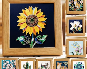 May include: A square wooden frame containing a stained glass-style sunflower art piece with yellow petals, a dark centre, and green leaves against a deep blue background. The collection includes other framed designs featuring a cat, flowers, a cactus, and dogs.