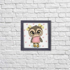 May include: A framed cross-stitch design featuring a cartoon owl with large eyes, wearing a pink dress and yellow flowers in its hair. The owl is surrounded by pink hearts on a white background.