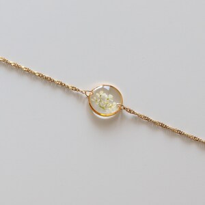 Goldenes Armband mit Anhänger Rund Gold mit weißen kleinen Blüten Geschenk Close Up Detail